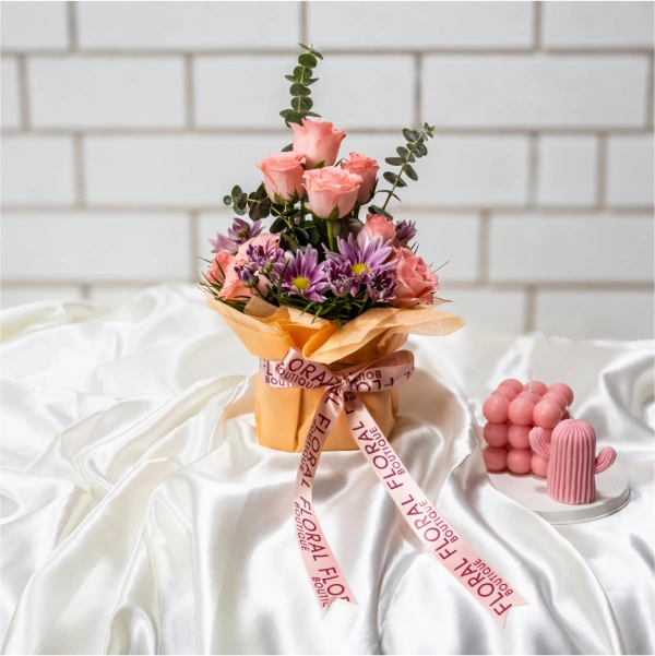 Blushful Blooms: A captivating arrangement of pink flowers dances in a sleek square glass vase