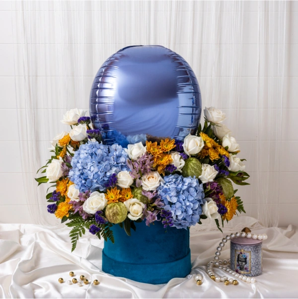 Azure Explosion: Dazzling blue flowers create a captivating display in a sleek blue round box